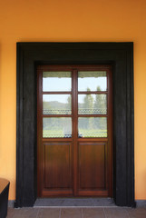 Fototapeta na wymiar Rural italian house with wooden door and orange wall