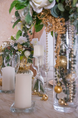 A table prepared for christmas party with  transparent glasses in white and gold colors. Christmas light. celebration table in restaurant or cafe with christmas decoration. magic garlands and candles.