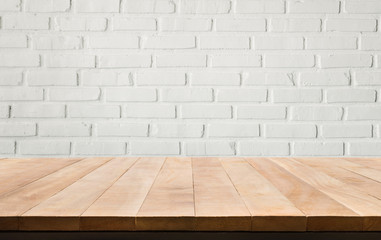Empty wood table top with white brick wall background.