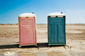 Portable unisex toilets on the beach.
