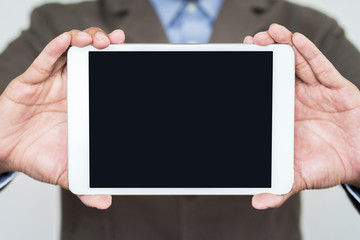 Businessman holding digital tablet  with blank screen, closeup