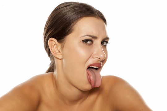 young woman with negative expression shows her tongue out
