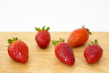 Fresh strawberries on wooden table with white background.