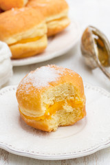 doughnuts with egg cream in white paper box on wooden background