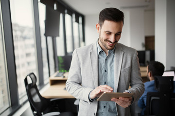 Picture of handsome man using tablet in office