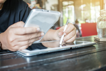 Obraz premium Businesswoman holds a white smartphone or smart device on her right hand and a stylus pen on the left hand, chats with friends via an instant messaging app over the public internet. Internet concept.