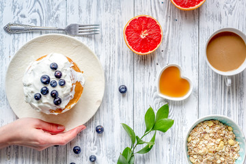 Breakfast concept with flowers on wooden background top view
