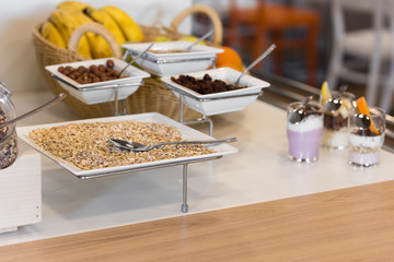 Breakfast in hotel, catering buffet. Plate filed with museli, corn flakes, oats and  raisins