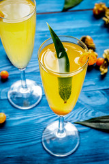 cocktail with physalis in glass on wooden background