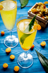 cocktail with physalis in glass on wooden background