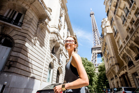 Fototapeta Lifestyle portrait of a young stylish woman walking the street with eiffel tower on the background in Paris