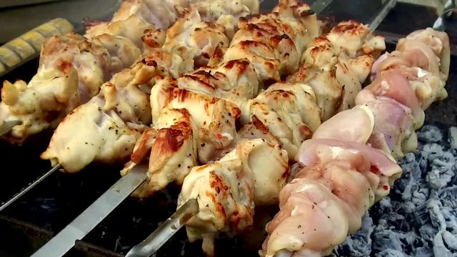 meat roasting on skewers in brazier outdoors