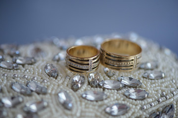 Wedding accessories: isolated beads and rhinestones embellished clutch with wedding bands, on blue suede leather cloth