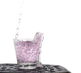 Pour water fresh into glass against the nature in shape water splash isolated on white background .