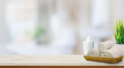 Towels in basket on top wood table with copy space on blurred bathroom background.  Copy space for Products Display Concept.
