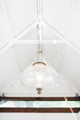 White vintage glass lamp in white interior of wooden house