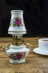 Obraz na płótnie Canvas beautiful vintage kerosene lampe and modern cup of coffee on rustic background 