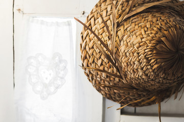 Texture of straw hat Bali style hanging on white wall close up © Oleg Breslavtsev