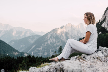 Woman sitting on a and enjoying beautiful landscape/ mountain and clouds 