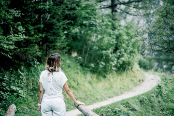 Woman crossing wooden bridge in forest