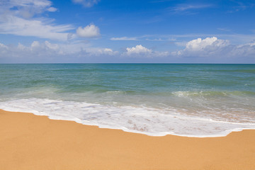 Sandy beach with soft wave on cloudy blue sky background in Phuket, Thailand