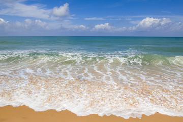 Sandy beach with soft wave on cloudy blue sky background in Phuket, Thailand