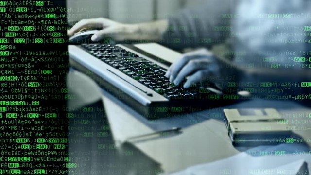 Random characters that look like the source code of a computer program, scrolling down, overlayed on the hands of a man typing on a pc keyboard.
