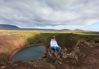 Person enjoys  beautiful northern landscape. Volcanic Kerid crater lake,  Iceland 
