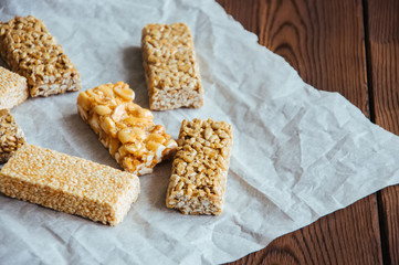 Snacks  - mix of energy bars with peanut, sesame and sunflower seeds on a wooden background
