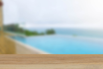 Vintage wooden tabletop on blurred pool and beach background, for display or montage your products