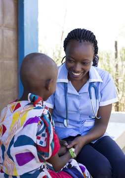 Nurse examining young girl in clinic. Kenya, Africa