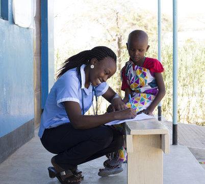 Nurse examining young girl in clinic. Kenya, Africa