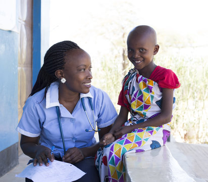 Nurse examing young girl in clinic. Kenya, Africa.