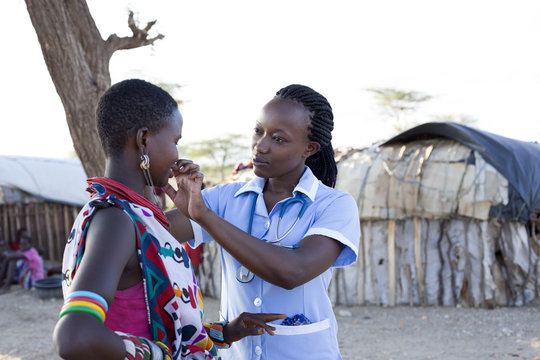 Nurse examing patient in rural village location. Kenya, Africa.