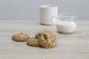 COOKIES AND COFFEE MUG
Oat meal raisin cookies and coffee with milk on the wood table. 