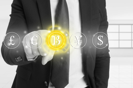 Businessman choosing bitcoin icon from virtual screen