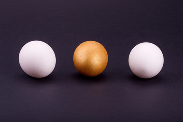 one golden egg with two white