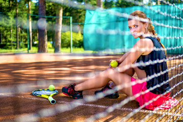 Obraz na płótnie Canvas Lower body closeup of tennis player woman resting sitting on outdoor court