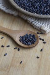 Black rice in a wooden plate. Closeup.