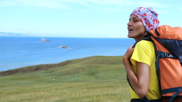 Hiking woman trekking along blue lake Baikal. Caucasian girl living active lifestyle
