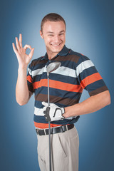 Emotional handsome golfer player pose in studio on blue and green background