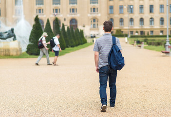 Young student walking to the university. Back view