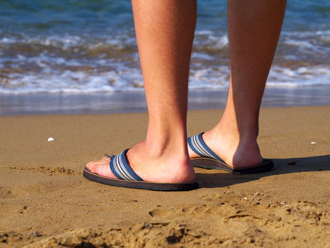 Man Wearing Slippers Standing On Beach