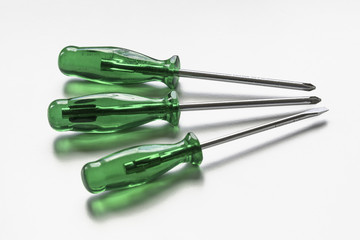 Three green screwdrivers, seen from sideways above