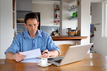 Obraz na płótnie Canvas Man in home office reading a document