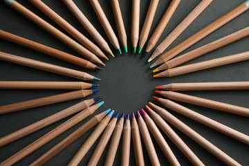 Many different colored pencils on black background