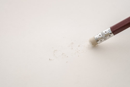 Closeup of pencil eraser and broken pencil on note book, soft focus. Business Mistake erase concept.
