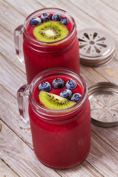 Berry kiwi smoothie in the jars, garnished with blueberries and kiwi