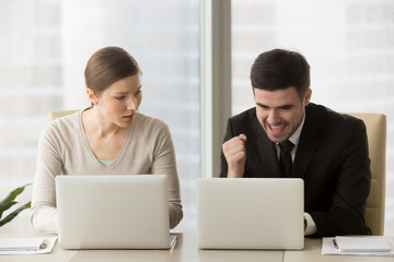 Resentful employee loser looks enviously at promoted colleague winner enjoying success, good news...