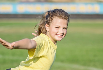 A young, pretty little girl doing sport exercises. Copy-space